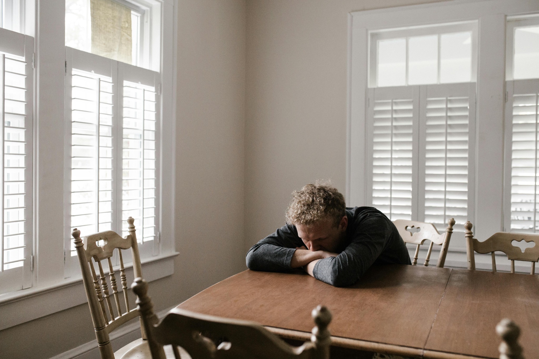 Teen sitting at a table looking upset